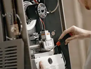 Furnace repair technician inspecting internal components and wiring in Lakeland, FL